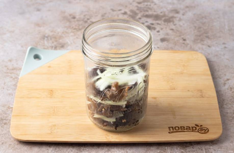 В чистую банку или пищевой контейнер выложите древесные грибы и репчатый лук слоями.