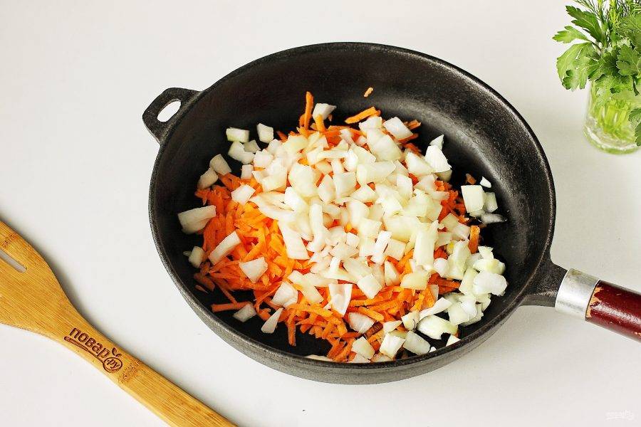 Лук нарежьте кубиками, морковь натрите на терке. Переложите овощи на хорошо разогретую сковороду, добавьте масло и обжарьте до мягкости.