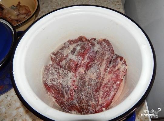 Обмываем мясо, нарезаем его довольно большими кусками. Утапливаем его в соли, хорошо натираем ею.