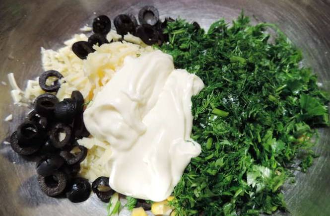 Перемешайте тертый сыр, маслины, рубленую зелень, консервированную кукурузу, посолите и поперчите. Добавьте сметану и все перемешайте.