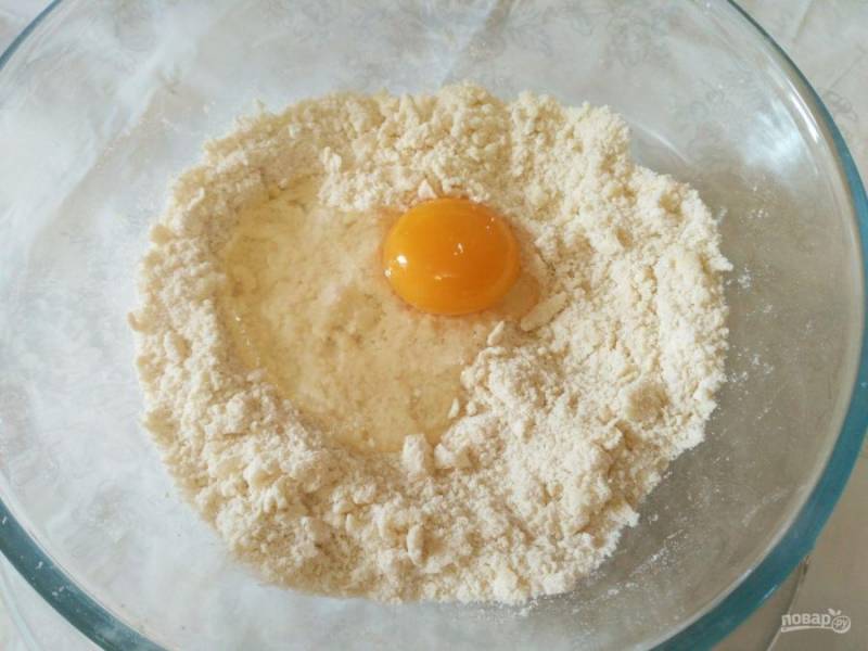 В получившуюся крошку разбейте яйцо, замесите тесто, при необходимости добавив немного муки или воды. 