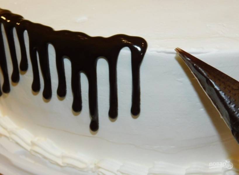 Налейте глазурь в кондитерский мешок и отрежьте кончик. По краю торта делайте небольшие шоколадные подтеки.