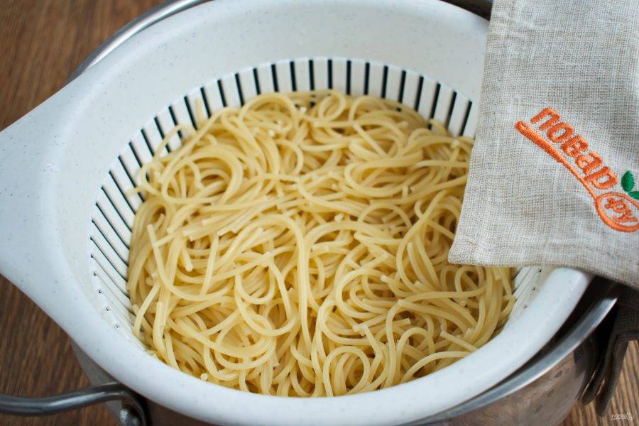 В кастрюлю с большим количеством кипящей соленой воды засыпьте спагетти, варите согласно инструкции, указанной на упаковке. После откиньте на дуршлаг.