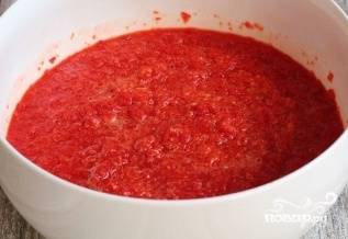 Теперь помытые перцы тоже пропустите через мясорубку, добавив к ним чеснок. Всыпьте сахар, добавьте соль. Перемешайте, влейте массу в томатное пюре.