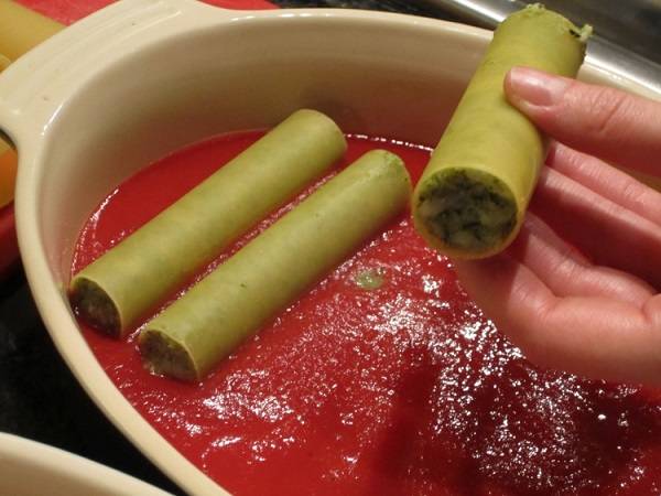 4. На дно жаропрочной формы вылить томатный соус. Добавить немного винного уксуса, соли и специй по вкусу. Выложить каннеллони.