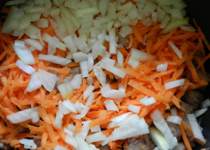2. Воду из чаши мультиварки сольем, туда закладываем мясо и измельченные лук и морковку. В режиме "Жарка" держим 10 минут, затем переставим в режим "Тушение" — и держим ещё 20 минут.