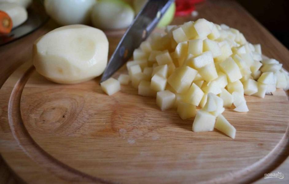 Картофель промойте, почистите и нарежьте кубиками.