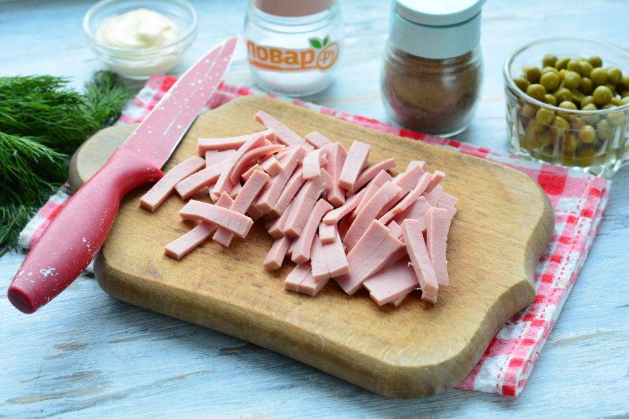 Нарежьте полосками вареную колбасу.