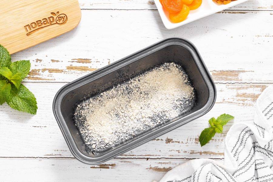 Смажьте форму для выпечки кокосовым маслом. Присыпьте дно планировочными сухарями.