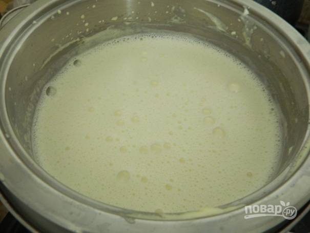 Тонкой струйкой вливаем горячее молоко во взбитые желтки и непрерывно помешиваем.