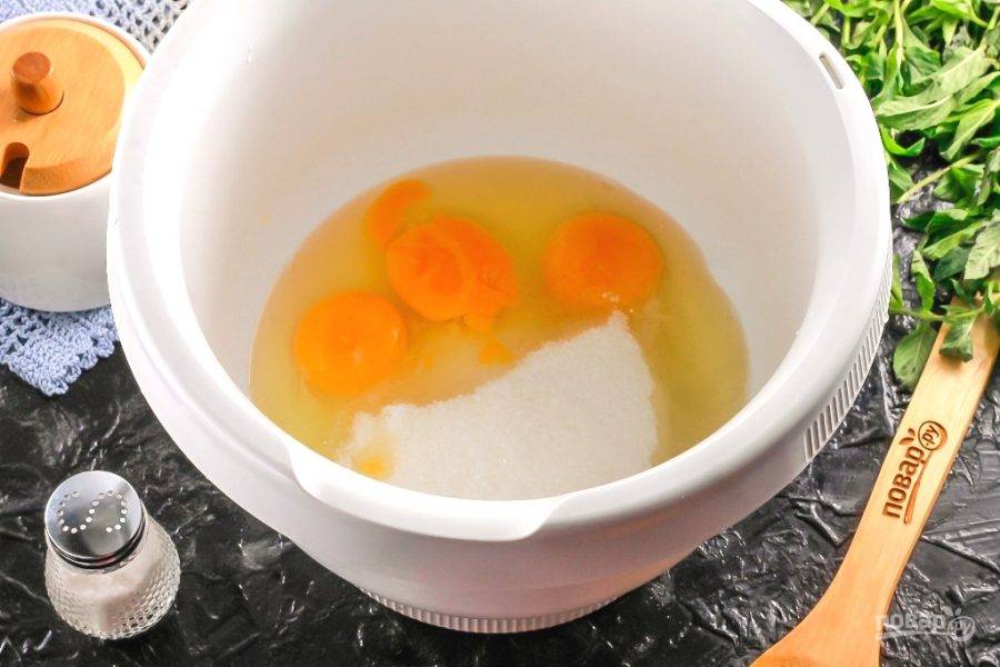 Вбейте куриные яйца в чашу миксера или кухонного комбайна. Всыпьте туда же соль и сахарный песок, взбейте все в течение 4-5 минут в пышную пену.