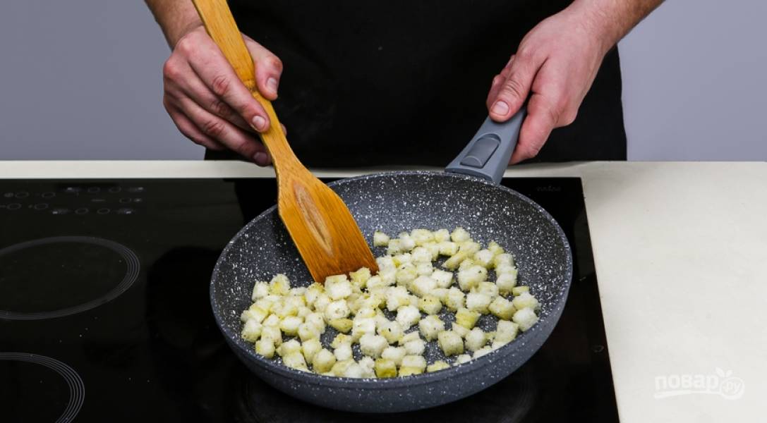В миске смешайте измельченный чеснок, 2 ст.л. оливкового масла, 1 ст.л. бульона и приправьте все солью с перцем. Хлеб нарежьте кусочками, обрежьте корки и нарежьте кубиками 1х1 см. Смешайте с соусом и поджарьте хлеб на сухой сковороде.