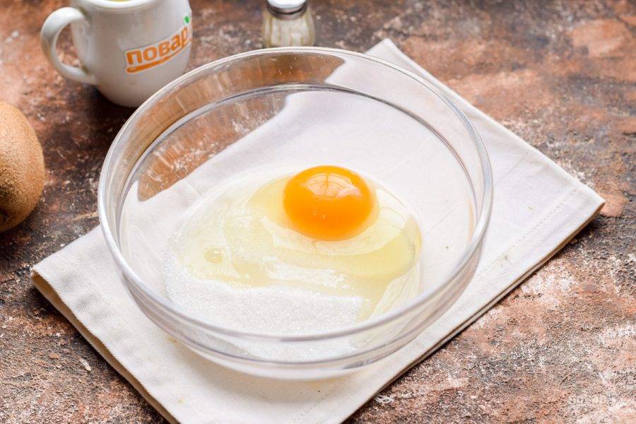 Переложите в миску куриное яйцо, добавьте сахарный песок.