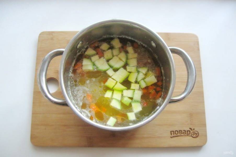 Через 10-15 минут приготовления картофеля, лука и моркови, добавьте в суп нарезанный небольшими кубиками молодой кабачок.