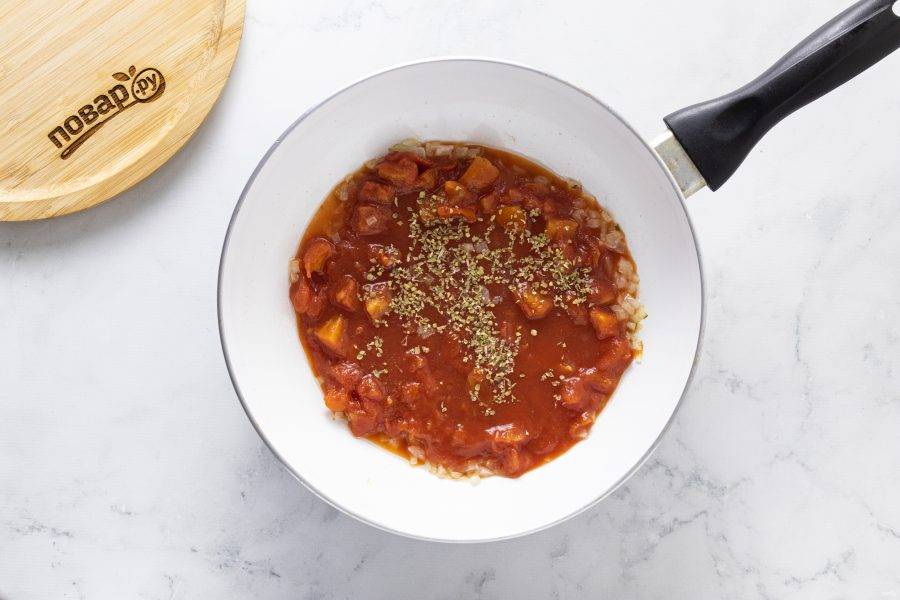 Влейте в сковороду измельченные томаты. Добавьте итальянские травы соль, черный молотый перец и щепотку перца чили. Доведите до кипения и на средне-сильном огне уваривайте его 5-7 минут.