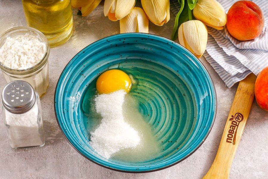 Влейте в глубокую емкость растительное масло, вбейте куриное яйцо, всыпьте соль и сахар. Тщательно размешайте.