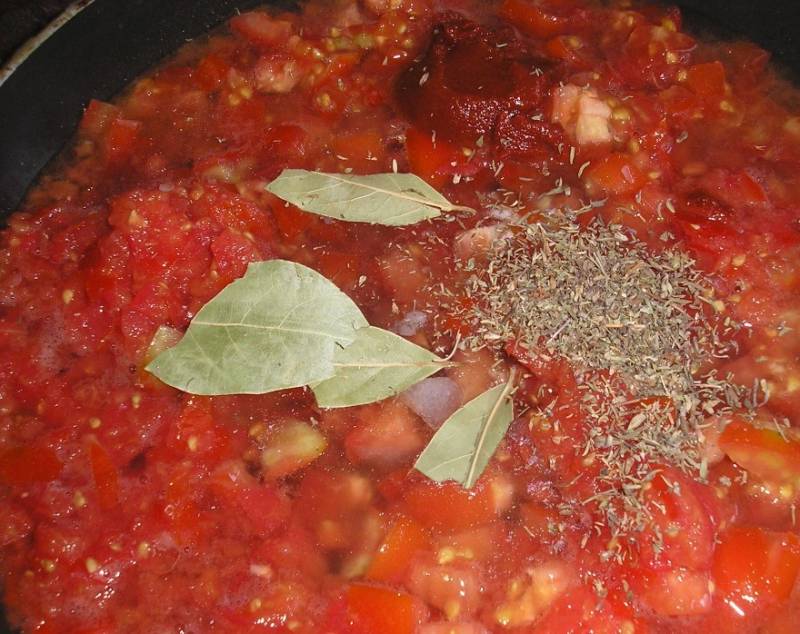 На сковороду добавляем: томатную пасту, помидоры, бульон, тимьян и лавровый лист. Доводим до кипения, варим на минимальном огне 5 минут.