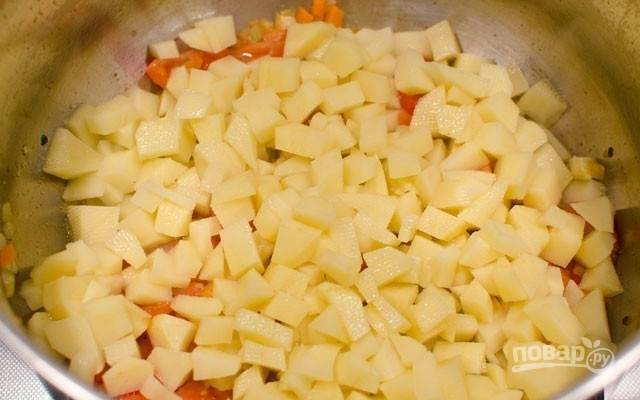 2.	Добавьте картофель, нарезанный небольшими кубиками, приправьте солью, черным перцем и обжаривайте все вместе несколько минут, до золотистого цвета картофеля.
