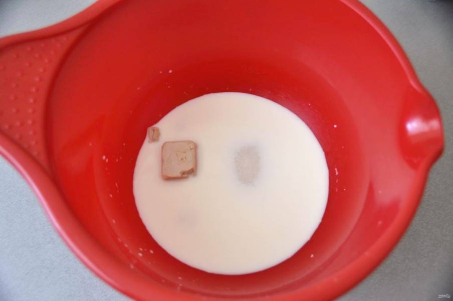 В теплое молоко добавьте дрожжи, 1 столовую ложку сахара от общего объема и размешайте  до растворения дрожжей.
