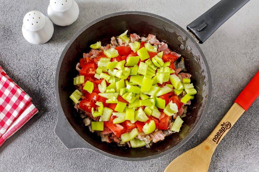 Затем добавьте нарезанные помидоры и болгарский перец (нарезка произвольная). Готовьте всё вместе периодически помешивая ещё около 3-5 минут.