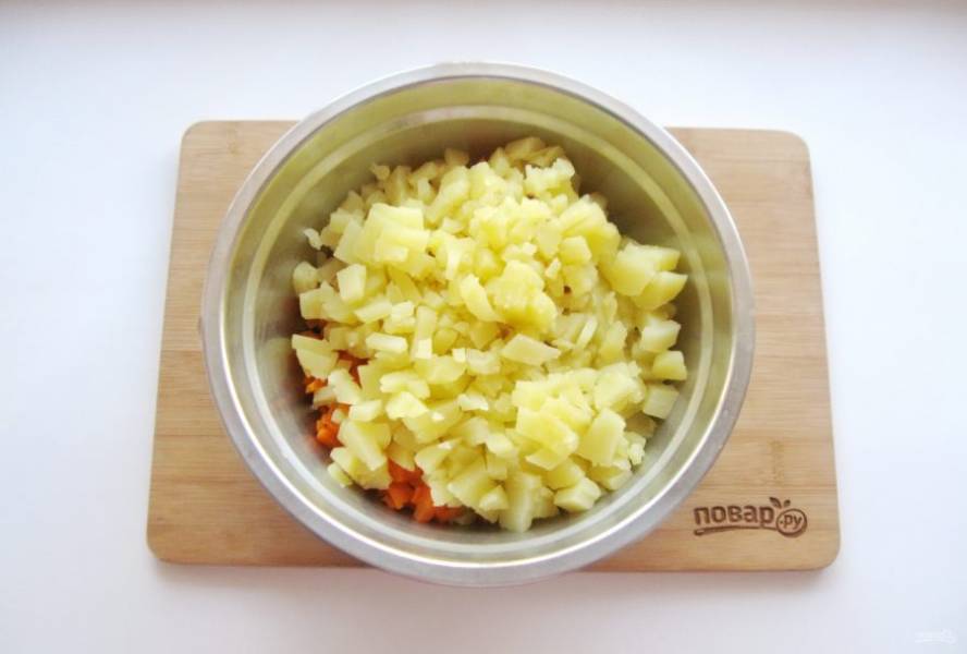 Картофель и морковь сварите в кожуре, охладите и очистите. Нарежьте небольшими кубиками и добавьте в миску.