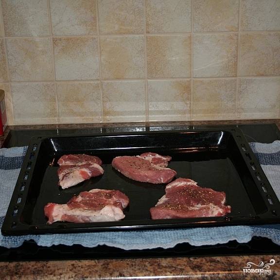 Выкладываем отбитые кусочки мяса на противень, смазанный маслом или застланный фольгой.