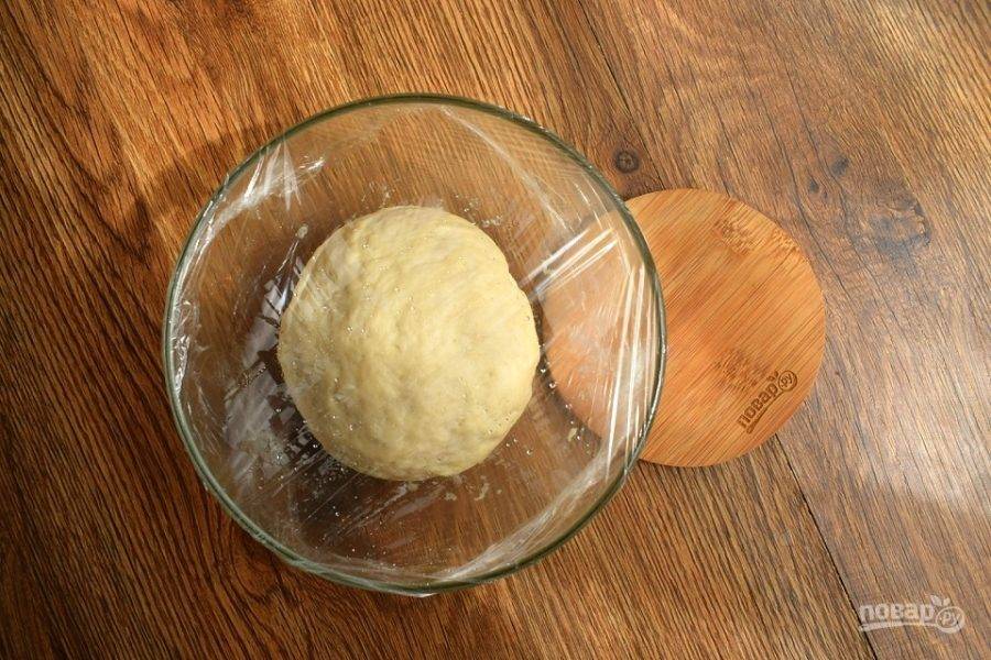 Замесите мягкое тесто, не липнущее к рукам. Поместите его в миску, смазанную маслом, накройте пищевой пленкой и оставьте в теплом месте на 40 минут для подхода.