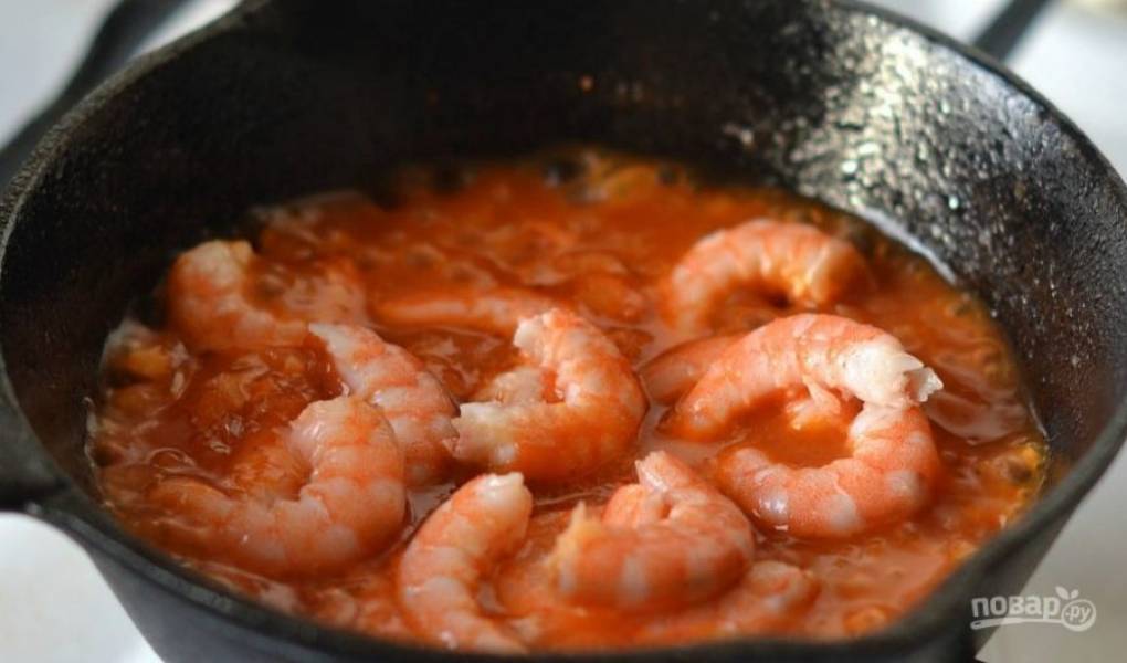 Креветки лучше использовать крупные, королевские. Очистите их от панциря и головы, выложите морепродукты в томатный соус. Тушите еще три минуты, периодически помешивая.  