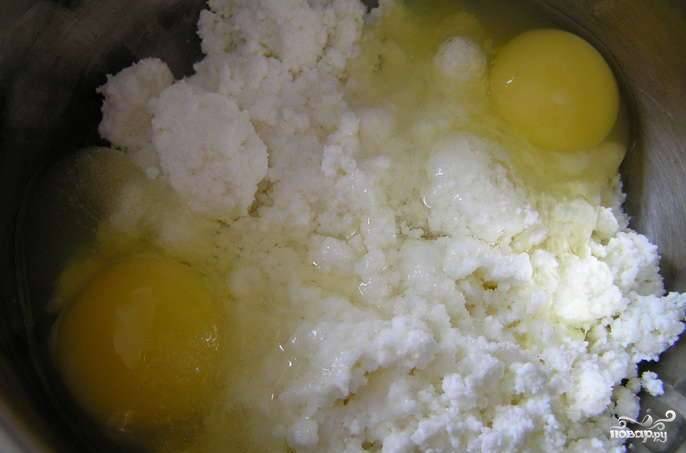 В миске разотрите яйца с творогом и солью.