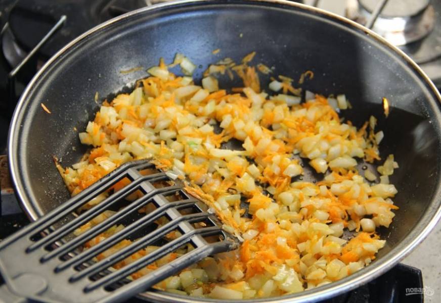 В сковороду влейте растительное масло и хорошенько разогрейте ее на плите. На среднем огне пассеруйте подготовленные лук и морковь до золотистого цвета. 