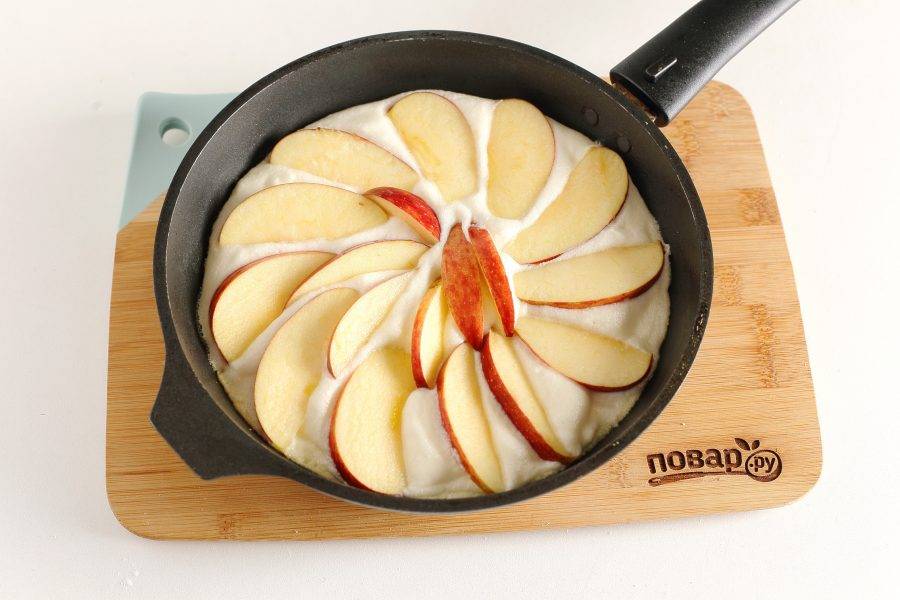 Смажьте сковороду сливочным маслом, выложите равномерно всю массу и сверху, чуть вдавливая, дольки яблок. Еще добавляют распаренный изюм, но это на любителя, я не добавляла. Закройте сковороду крышкой и на среднем огне зажарьте блинчик до золотистого цвета. Затем переверните (я делала это при помощи тарелки) и тоже зажарьте до готовности. 