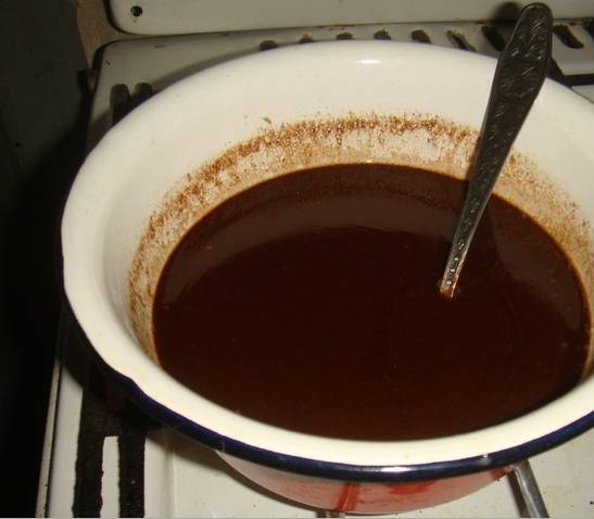 2. На водяной бане растопим шоколад, немного меда и масло. Эту смесь лучше взбить миксером, пока не остыла. От глазури берем примерно полстакана, смешиваем с измельченным черносливом и частью орехов. 