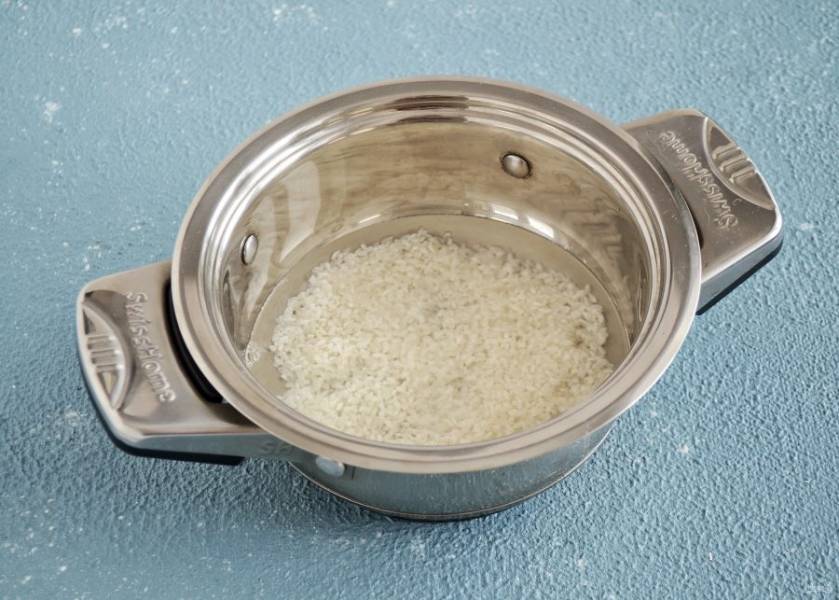 Рис промойте до прозрачности, залейте водой и поставьте на большой огонь. Доведите до кипения, снизьте температуру до средней и варите рис 10 минут. 