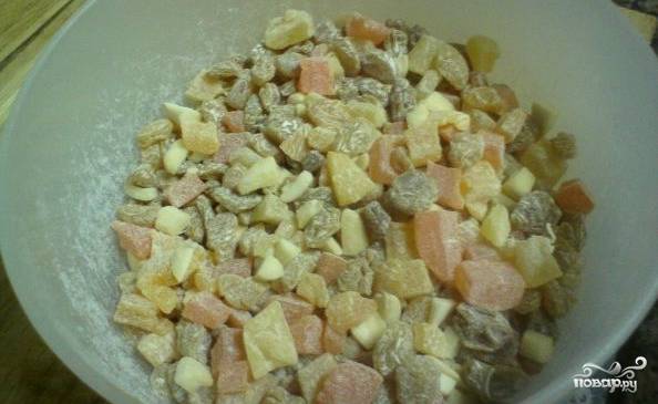 Пока тесто поднимается, смешиваем в миске орехи с цукатами и изюмом. Перемешиваем их с небольшим количеством муки.