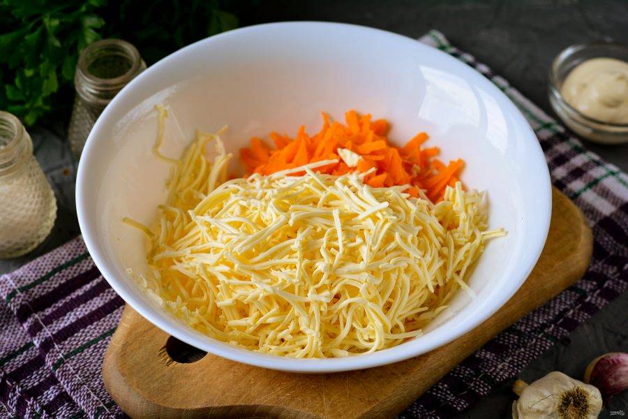 Сложите морковку в миску, туда же натрите на терке плавленый сыр.