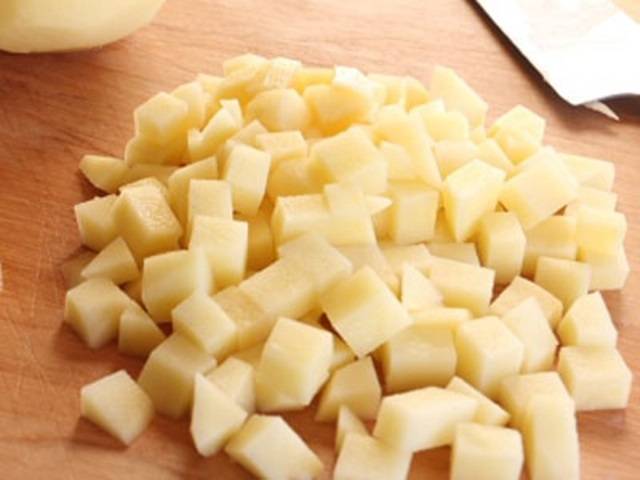 Картофель порежьте кубиками, сложите в миску и залейте водой, чтобы он не почернел до того момента, пока не понадобится. 