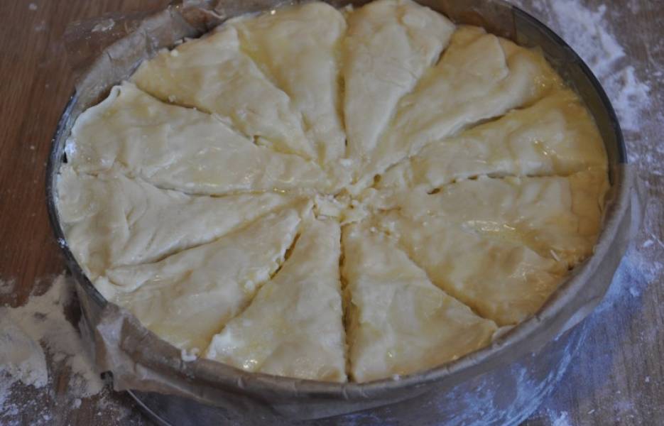 Ножом разделяем ачму на порционные кусочки. В прорези вливаем остатки растопленного масла.