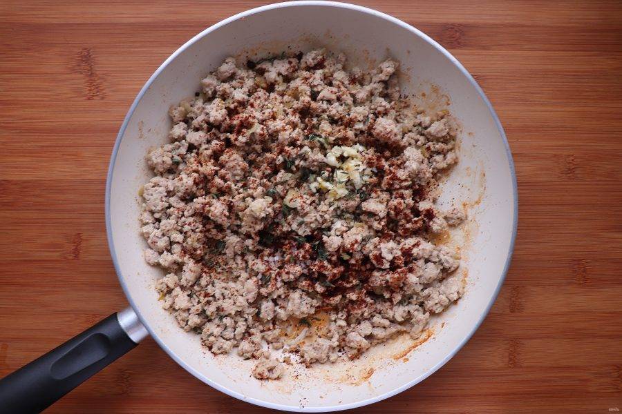 Теперь добавьте корицу, соль, перец, мускатный орех, тимьян, паприку и измельченный чеснок. Готовьте еще 1 минуту.