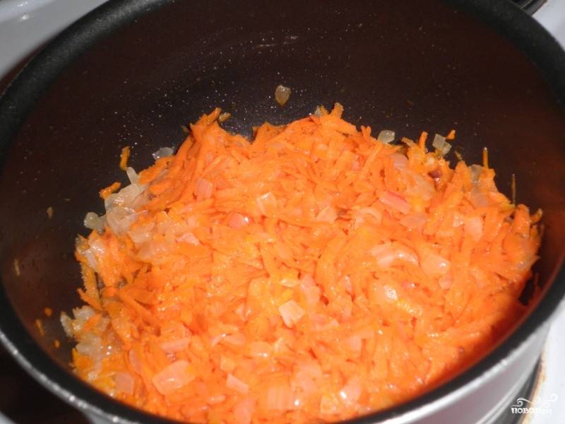 Через пару минут добавляем морковь, тертую на терке. Перемешиваем, обжариваем еще несколько минут. 