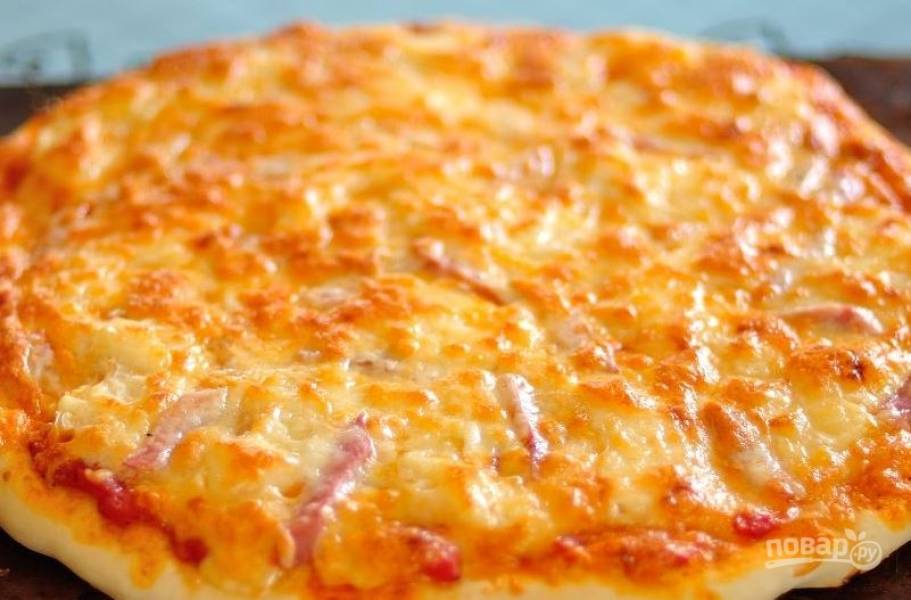 Разогрейте духовку до ста восьмидесяти градусов, поставьте в нее пиццу. Запекайте блюдо двадцать минут, чтобы на сыре образовалась румяная корочка. 