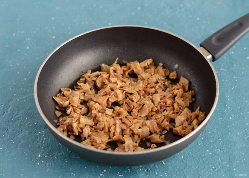 Разогрейте сковороду на среднем огне. Обжарьте лук и чеснок порезанный кубиками до мягкости. Добавьте растительное мясо, влейте соевый соус и посыпьте грибной приправой. Жарьте все вместе 6-8 минут. 