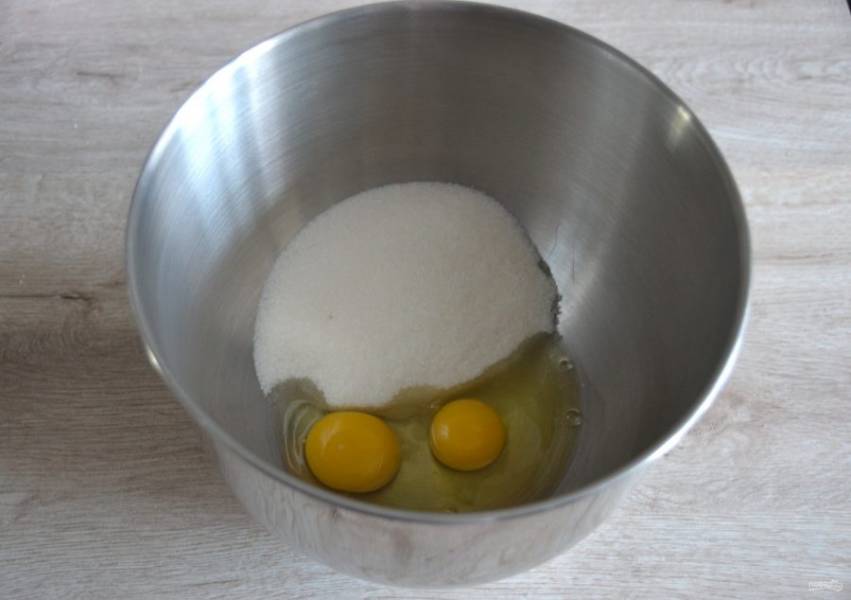 В емкость для взбивания вбейте 2 яйца, всыпьте 200 грамм сахара, взбейте до пышности.
