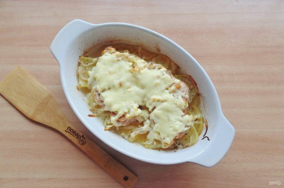 Отправьте корейку с картофелем и луком в духовку, разогретую до 185-190 градусов. Запекайте 40-45 минут. После достаньте, посыпьте тертым сыром и запекайте еще 5-7 минут до расплавления сыра.