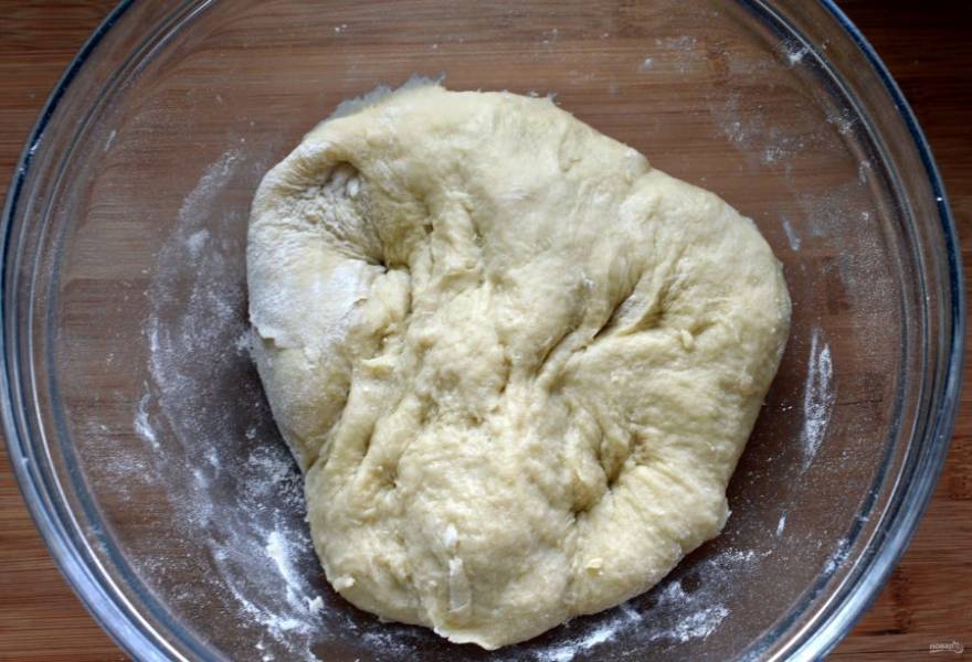 Масло растопите и влейте в тесто. Вымешивайте тесто до тех пор, пока оно не станет отставать от рук и от миски. Я вымешиваю тесто в хлебопечке, поэтому всыпаю всю муку сразу. Если будете месить вручную, вводите муку в несколько этапов.