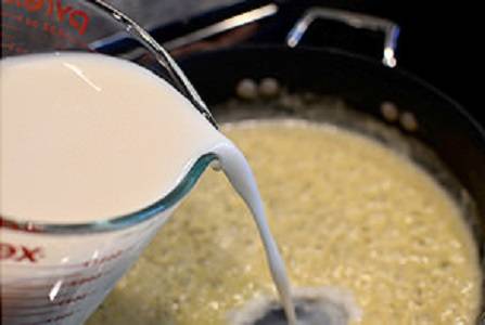 3. Тонкой струйкой влить на сковороду молоко. Когда начнут появляться пузырьки, убрать огонь до минимума и варить соус 3-5 минут. При желании можно использовать также сливки, в равных пропорциях с молоком. 