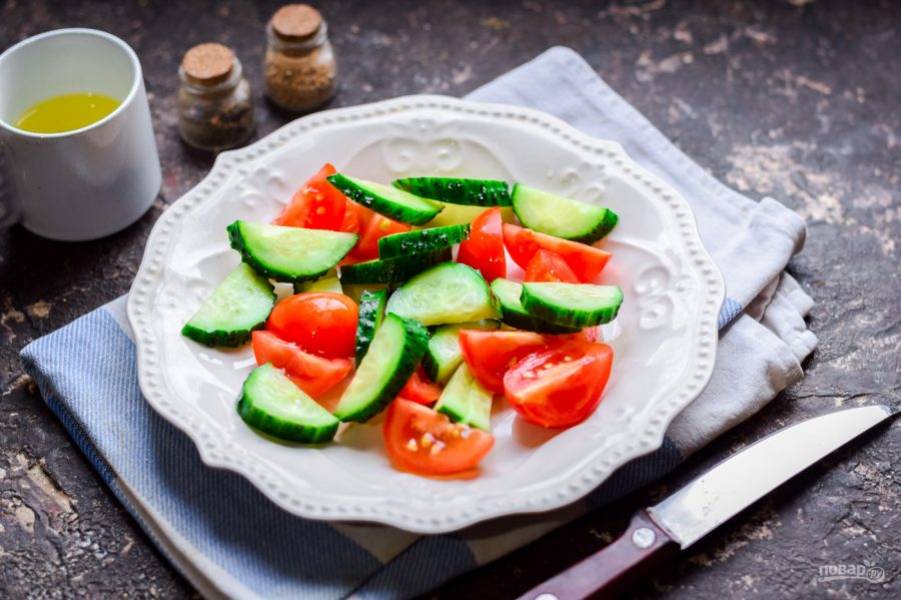 Сполосните помидоры и огурец, нарежьте небольшими кусочками и переложите в тарелку.