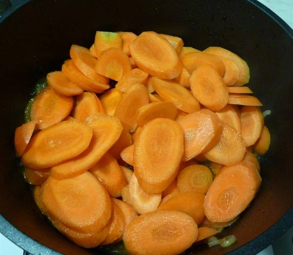 Добавляем морковь, порезанную колечками. Перемешиваем, продолжаем готовить.