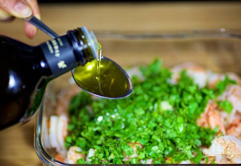4. Поместите к креветкам нарезанный лук, кинзу и оливковое масло. Перемешайте маринад.