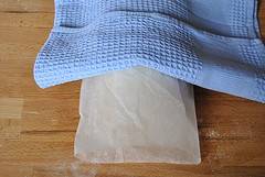 4. Накройте тесто пергаментом, сверху - кухонное полотенце и отправьте на 2,5 часа в выключенную духовку.