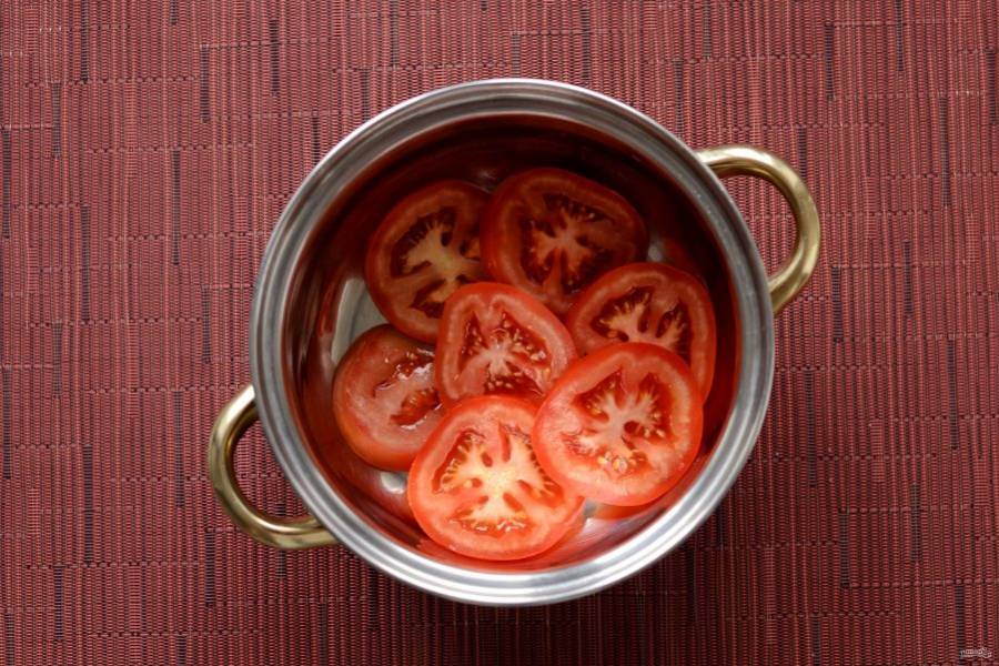 На дно кастрюли или глубокой миски выложите помидоры в один слой. 